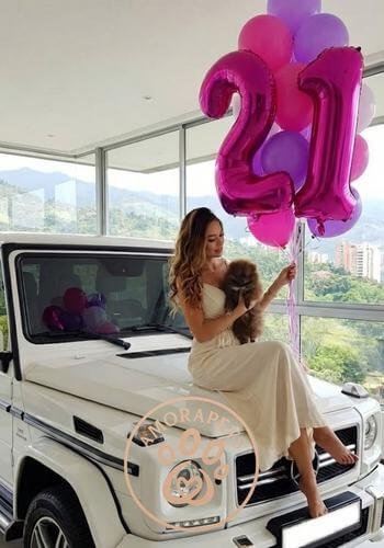 Chica joven recibiendo un cachorro Pomerania chocolate mini como regalo de 21 años en Las Palmas, Medellín. Entrega de lujo por AmoraPets en El Poblado.
