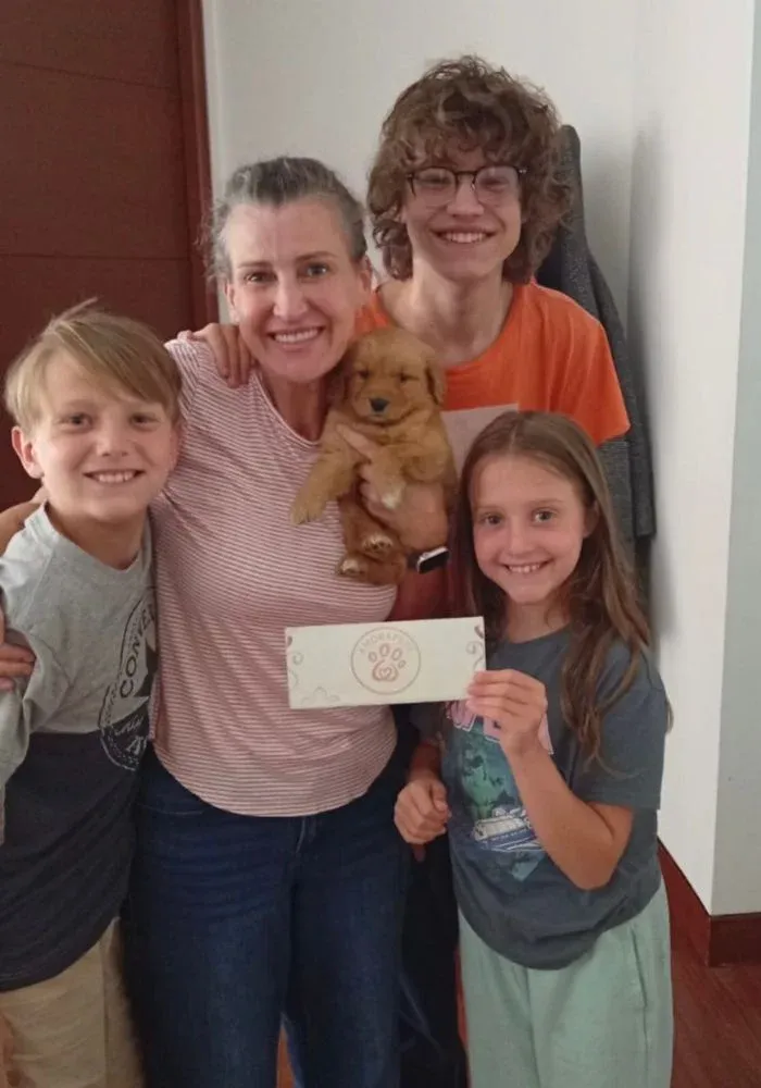 Familia feliz recibiendo su cachorro Golden Retriever de AmoraPets en Colombia